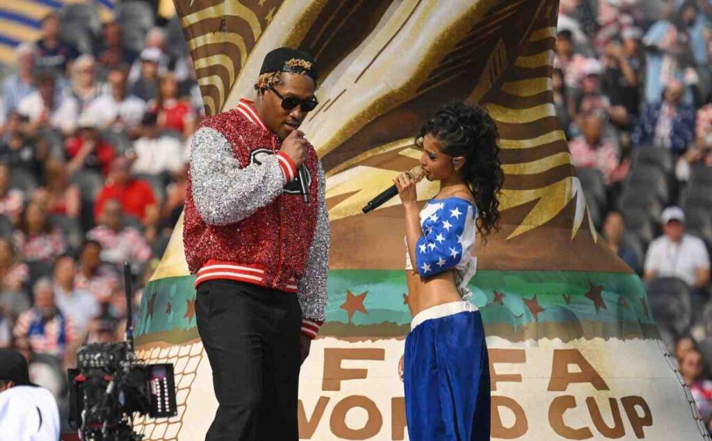Future Tyla Trybal News Two singers Future Tyla perform on a parade float man in a red sequined jacket and woman in a blue stars outfit sing into microphones at the Opening Ceremony of The FIFA World Cup in USA trybalnews