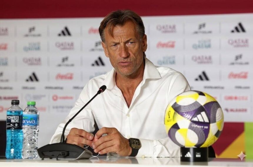 Man in a white shirt sits at a press conference microphone in front with water bottles and a colorful soccer ball on the table  trybalnews