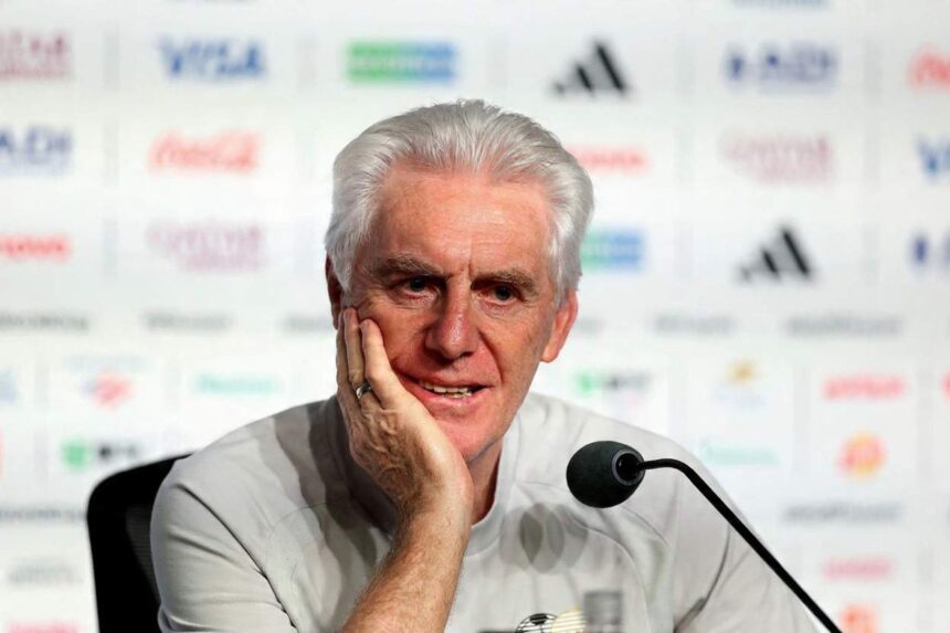 Hugo Broos white haired South Africa head coach in a light gray shirt sits at a press conference table with a microphone He rests his chin on his hand with a thoughtful expression Sponsor logos are blurred in the background Atlanta Stadium FIFA World Cup 2026 Group A June 18 2026  trybalnews