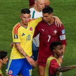 Colombia midfielder James Rodriguez wearing a yellow kit with number 10 and blue shorts stands next to Portugal forward Cristiano Ronaldo wearing a red kit with number 7 Rodriguez has his arm around Ronaldos shoulder in a post match moment A staff in white and other players in training bibs are visible on the green pitch The 2026 FIFA World Cup Group K match between Colombia and Portugal took place on June 27 2026 at Miami Stadium in Miami United States  trybalnews