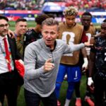 Canada head coach Jesse Marsch wearing a grey quarter zip with the Canada Soccer crest speaks and points to his players in a post match huddle Staff and players surround him including a man in a green Canada top on the left a staff member in a suit with a red tie and Canada players in black speckled kits and brown training bibs with 22 visible The 2026 FIFA World Cup Round of 32 match between South Africa and Canada was played on June 28 2026 at Los Angeles Stadium in Inglewood California with Canada advancing to the Round of 16 A packed stadium crowd is blurred in the background  trybalnews