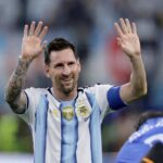 Argentina footballer in a blue and white striped kit raises both hands in celebration to the crowd  trybalnews