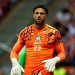 Nigerian goalkeeper in bright orange jersey with number 23 gloves on standing on the field during a match  trybalnews
