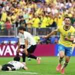 Brazil forward Gabriel Martinelli wearing a yellow 22 Brazil kit with blue shorts and pink cleats celebrates after scoring Brazils second goal He is running with arms outstretched and mouth open in celebration on the pitch Behind him two Japan players in white kits are dejected one lying on the grass and another running away The FIFA World Cup 2026 Round of 32 match between Brazil and Japan took place on June 29 2026 at Houston Stadium in Houston Texas A packed stadium of yellow clad Brazil fans cheers in the background with Qatar Airways hoardings visible around the pitch  trybalnews