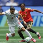 Two soccer players chase a ball during a match white jersey number 9 versus red jersey number 25 both reaching for the ball on the field  trybalnews