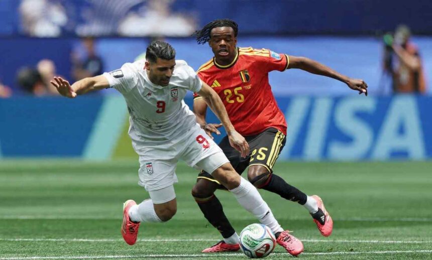 Two soccer players chase a ball during a match white jersey number 9 versus red jersey number 25 both reaching for the ball on the field  trybalnews