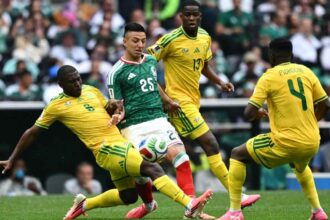 Soccer match action: a Mexican player controls the ball as South African defenders close in.
