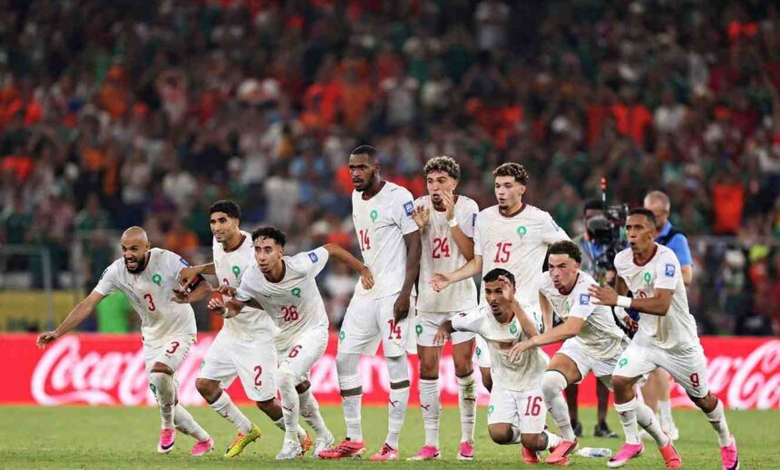Morocco football players in white Puma kits with red numbers dash forward in celebration on the pitch The group includes players wearing 3 2 26 14 24 15 16 and 9 all with arms outstretched mouths open and intense expressions of joy This is after Ismael Saibari 11 scored Moroccos fifth and winning penalty in the shootout The FIFA World Cup 2026 Round of 32 match between Netherlands and Morocco was played on June 29 2026 at Monterrey Stadium in Guadalupe Mexico A packed stadium crowd and a red Coca Cola advertising hoarding are visible in the background  trybalnews