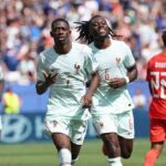 France forward Ousmane Dembele 7 in a light mint green away kit with gold number 7 and the FFF rooster crest runs forward with both hands gesturing after scoring Midfielder Manu Kone 6 with dreadlocks wearing the same kit with gold number 6 smiles and runs beside him A Norway player 22 in a red kit walks away in the background 2026 FIFA World Cup Group I match between Norway and France at Boston Stadium Foxborough on June 26 2026 Packed crowd and blue advertising boards behind the pitch  trybalnews