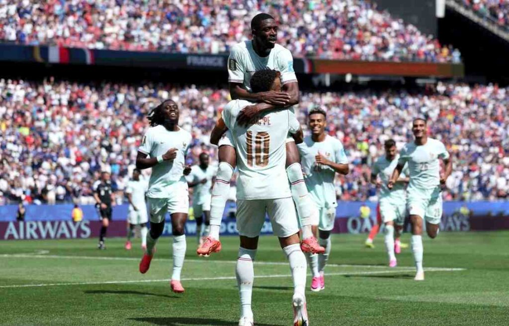 France forward Ousmane Dembele 7 in a light mint green away kit jumps onto the back of captain Kylian Mbappe 10 who is wearing the same kit with gold number 10 and name MBAPPE on the back Dembele wraps his arms around Mbappe in celebration on the pitch France teammates run in behind them at Boston Stadium 2026 FIFA World Cup Group I match between Norway and France on June 26 2026 in Foxborough Massachusetts Packed crowd and blue advertising boards are visible in the background  trybalnews