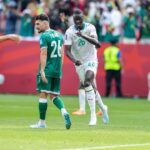 Senegal midfielder Pape Gueye 26 in a white away kit with green trim and number 26 runs forward pointing with his right index finger to celebrate Beside him Iraq midfielder Frans 26 in a green home kit with white number 26 walks away with his head down Another Senegal teammate is blurred in the foreground 2026 FIFA World Cup Group I match between Senegal and Iraq on June 26 2026 at Toronto Stadium in Toronto Ontario Red stadium hoarding and fans in green Senegal shirts are visible in the background  trybalnews