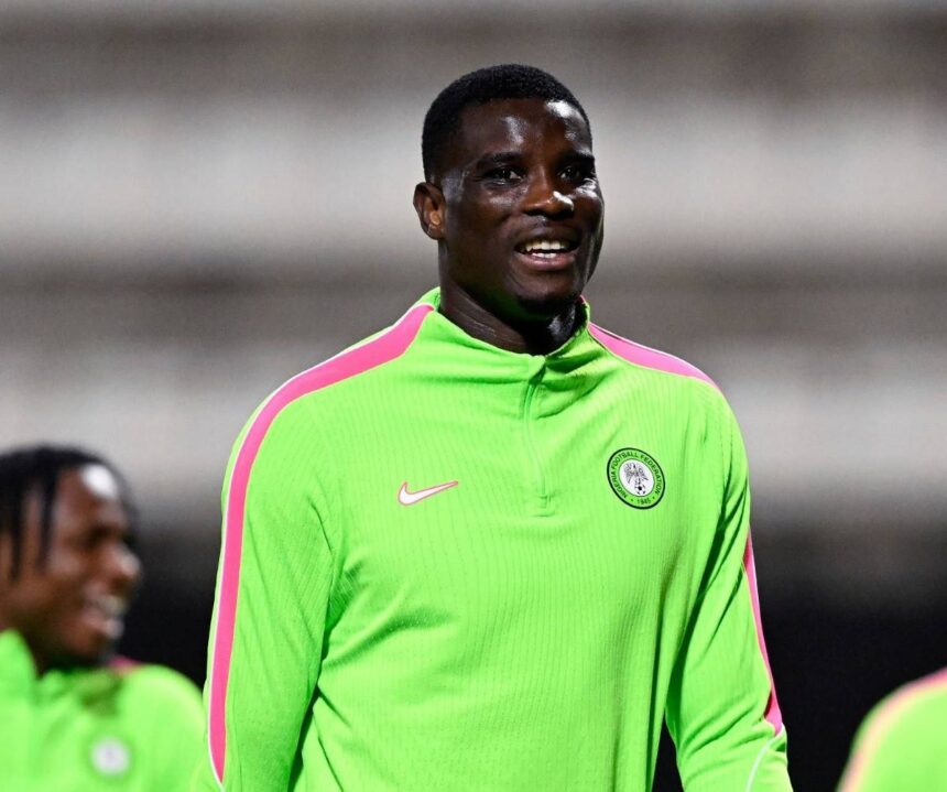 Footballer in neon green training top with pink stripes on the shoulders smiling on the field  trybalnews