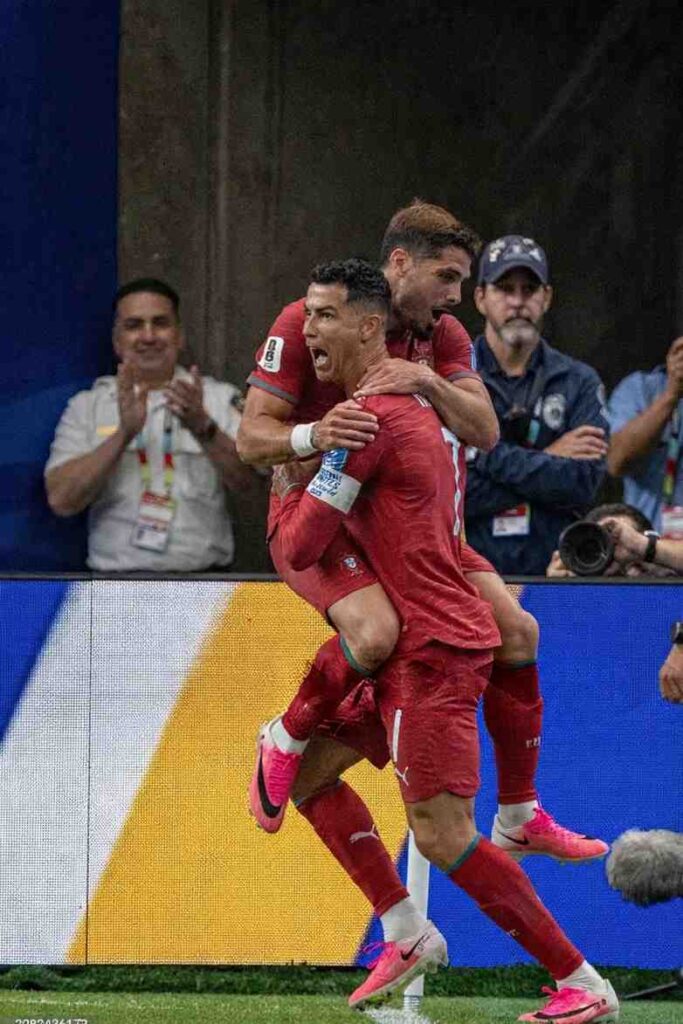Ronaldo Neto Trybal News Portugal forward Cristiano Ronaldo in red 7 jersey celebrates with teammate Pedro Neto wearing 18 after scoring Portugalaposs third goal Both players embrace on pitch during FIFA World Cup 2026 Group K match vs Uzbekistan at Houston Stadium Houston United States on June 23 2026 LED advertising boards visible in background trybalnews