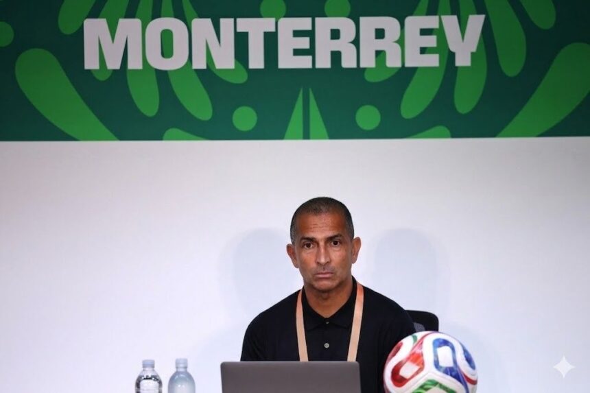 Man at a press conference desk with a laptop two water bottles and a colorful soccer ball MONTERREY banner behind  trybalnews