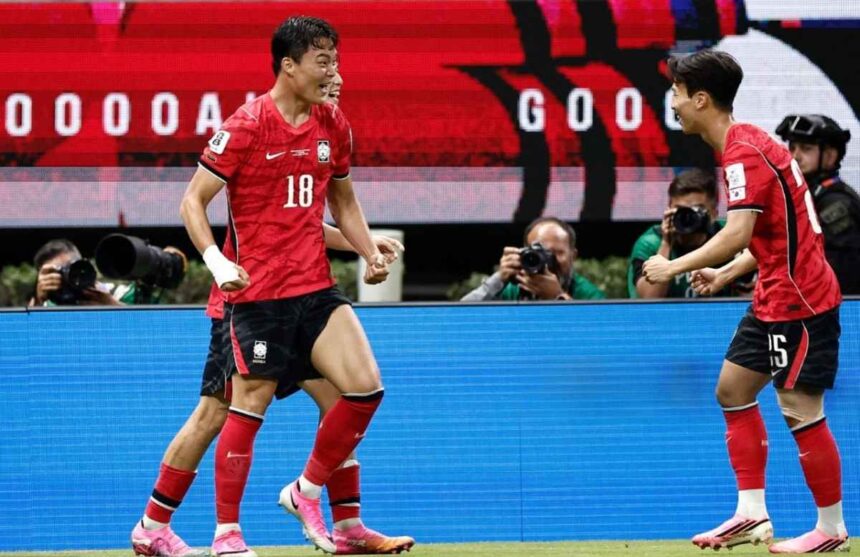 Two soccer players in red uniforms celebrate on the field as photographers film in the background  trybalnews