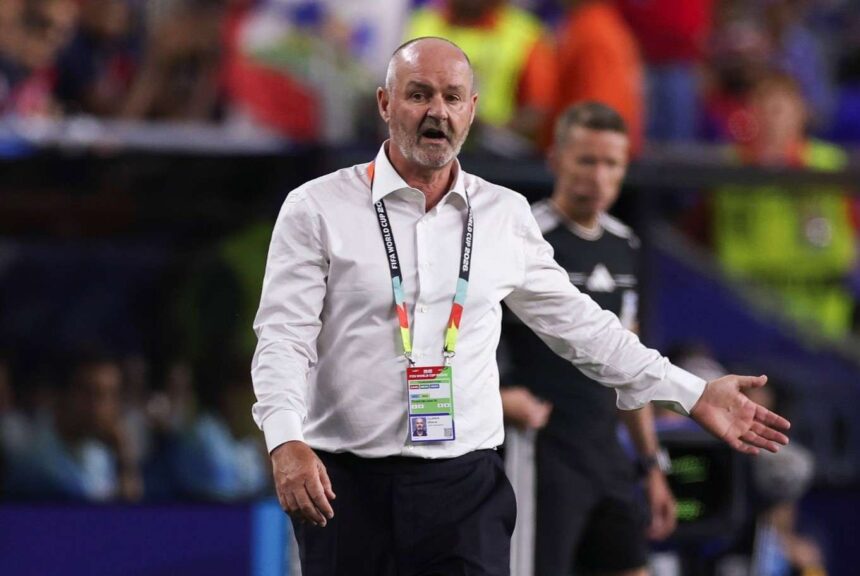 Sports official in a white shirt with an ID badge gesturing with an outstretched arm on a stadium court with a blurred crowd behind  trybalnews