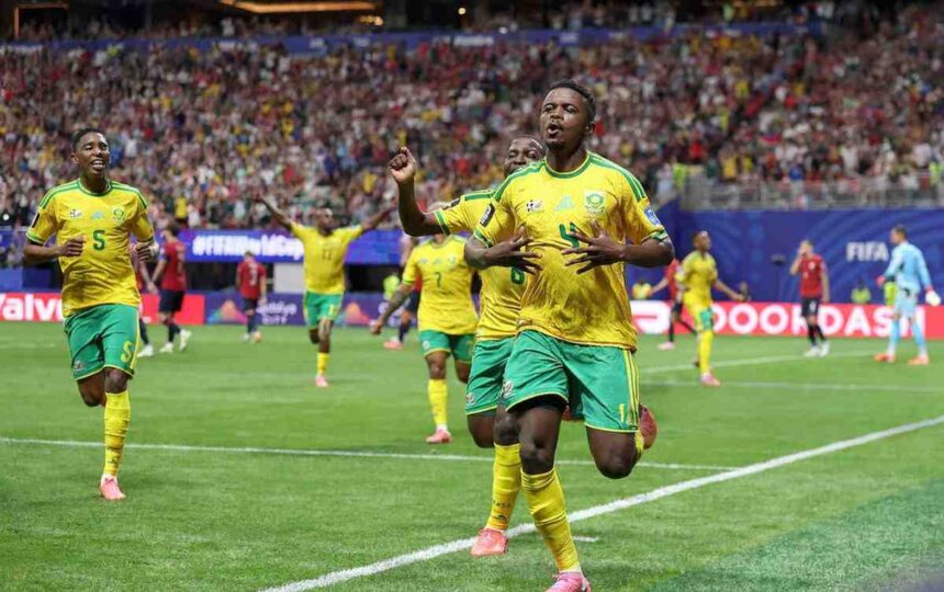 South African footballer Teboho Mokoena celebrates with arms raised after scoring a penalty kick He wears a green and yellow South Africa jersey The FIFA World Cup 2026 match between Czechia and South Africa is at Atlanta Stadium June 18 2026 Crowd and stadium visible in background  trybalnews