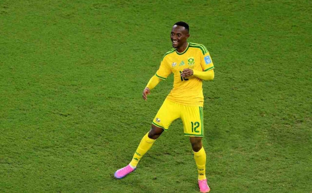 Thapelo Maseko Trybal News South Africa winger Thapelo Maseko wearing yellow 12 jersey with green trim matching shorts and socks and pink football boots celebrates after scoring He has short black hair is smiling and runs on the green pitch with arms slightly out FIFA World Cup 2026 Group A match between South Africa and Korea Republic at Monterrey Stadium Guadalupe Mexico on June 24 2026 South Africa crest and Adidas logo visible on kit trybalnews