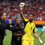 Football goalkeeper in a yellow jersey with number 1 Vozinha raises a gloved fist as teammates celebrate on the field  trybalnews