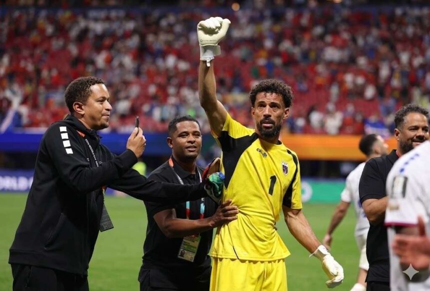 Football goalkeeper in a yellow jersey with number 1 Vozinha raises a gloved fist as teammates celebrate on the field  trybalnews
