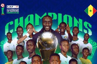 Senegal U-17 football team players pose with a large trophy and the word 'Champions' in the background, celebrating the CAF U-17 Africa Cup of Nations 2017.