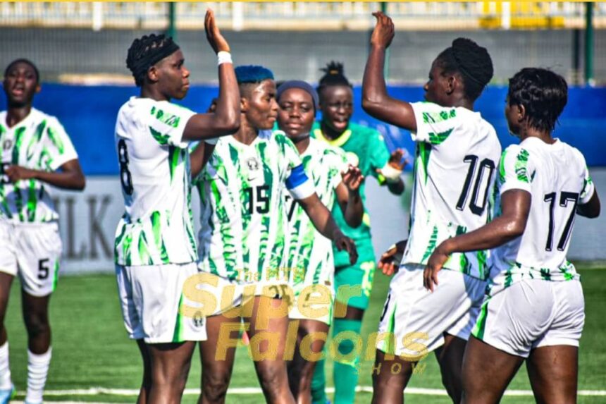 Group of female soccer players in white and green uniforms celebrate with raised arms on a green field after a goal or win  trybalnews