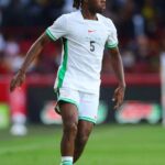 Soccer player in a white Algeria kit with green trim number 5 on a grassy field during a match  trybalnews