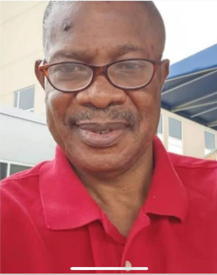 Portrait of an older man wearing glasses and a red polo shirt smiling slightly outdoors near a building  trybalnews