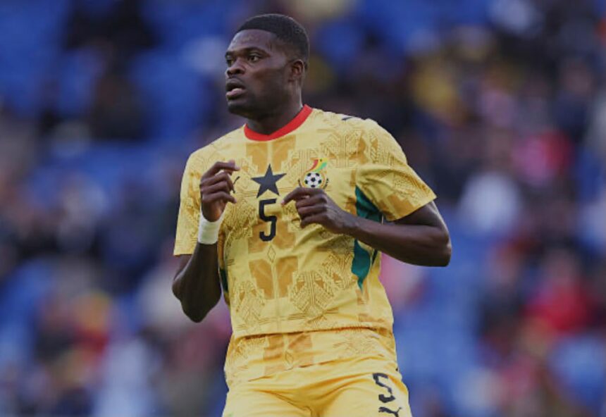 Soccer player in a yellow Ghana kit with number 5 running on a field with blurred blue seats in the background  trybalnews