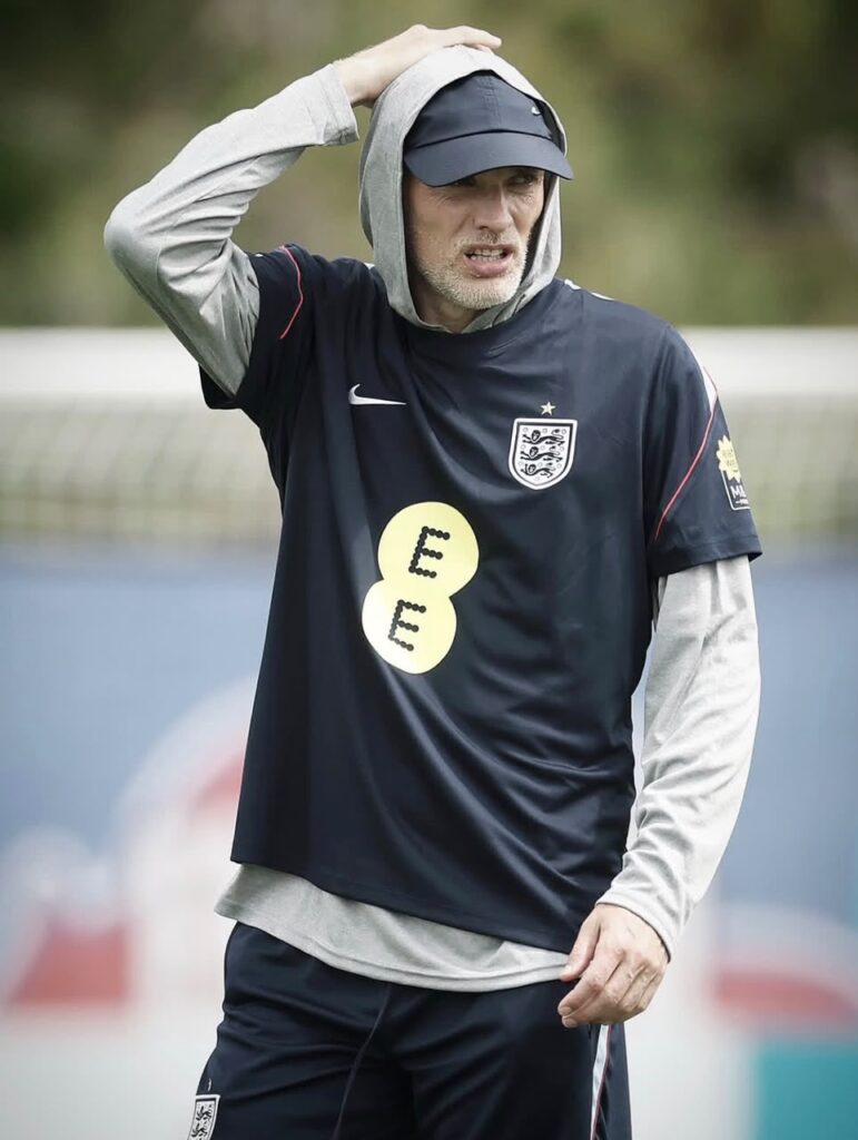 Man in England football training gear on a practice field hood up and hand on head looking focused  trybalnews