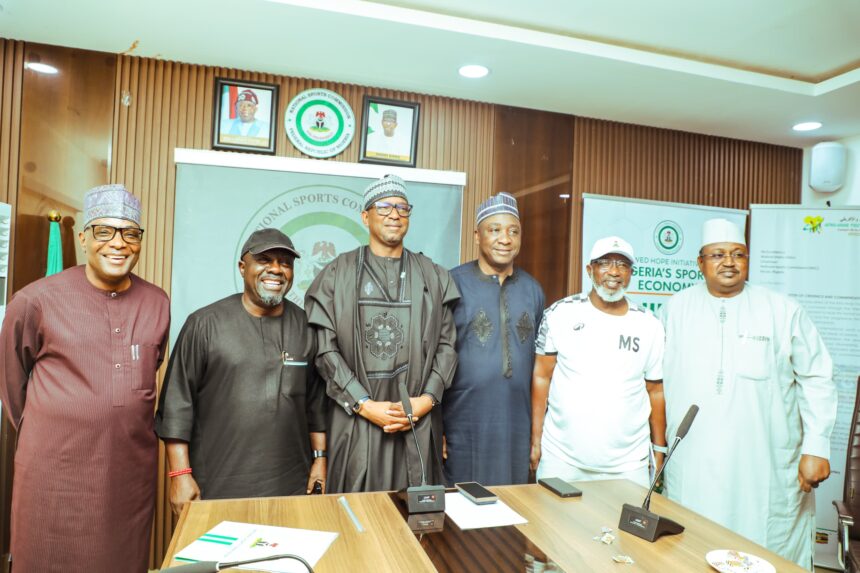 Group of six men in traditional Nigerian attire pose for a photo at a press conference standing behind a wooden table with microphones and banners in a formal room  trybalnews