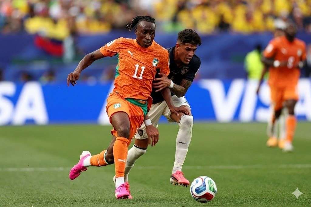 Yan Diomande Trybal News Two soccer players contest the ball during a match one in orange for Côte daposIvoire with number 11 and pink cleats being challenged by a Hincapie of Ecuador in a dark kit on a green field trybalnews