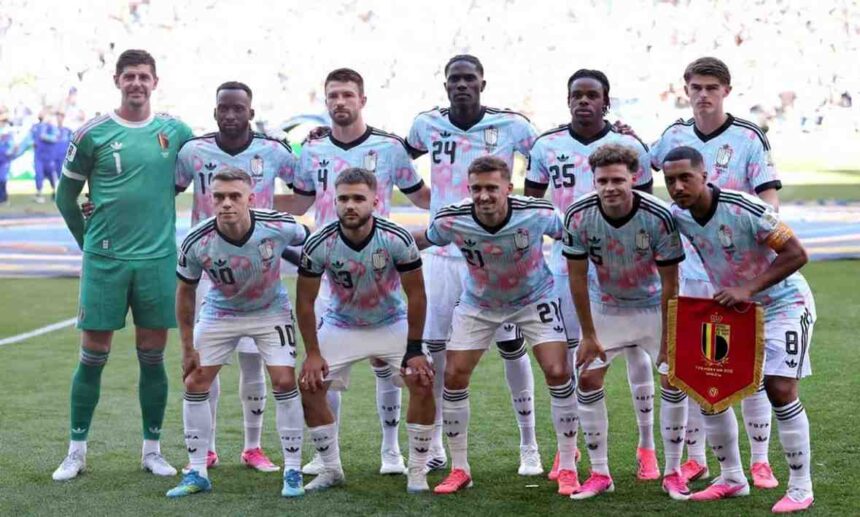 Belgium national team players pose for a team photo before the FIFA World Cup 2026 Round of 16 match against USA at Seattle Stadium in Seattle on July 6 2026 The goalkeeper wears a green kit while outfield players wear light blue and pink patterned away jerseys with white shorts A player holds a red Belgium pennant  trybalnews