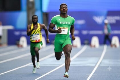 Nigerian sprinter Favour Oghene Tejiri Ashe runs on the track in a green Nigeria kit during the men's 100m heats. He is in the lead, with another athlete in yellow and green behind him. The race takes place at Scotstoun Stadium during the Glasgow 2026 Commonwealth Games. Photo by Rob Casey/SNS Group via Getty Images