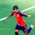 Ferran Torres of Spain wearing a red jersey with number 7 celebrates on the green pitch with arms outstretched and one leg lifted after scoring Spains first goal in the FIFA World Cup 2026 Final against Argentina at MetLife Stadium in East Rutherford New Jersey  trybalnews