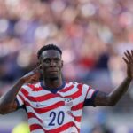USA forward Folarin Balogun wearing the 20 red and white striped home kit celebrates with his finger to his ear and one arm raised after scoring his teams first goal during the FIFA World Cup 2026 Round of 32 match against Bosnia and Herzegovina at San Francisco Bay Area Stadium in Santa Clara California on July 1 2026  trybalnews