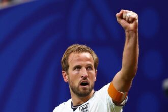 England captain Harry Kane, wearing the #9 white home kit with an orange captain’s armband, celebrates with a raised fist after scoring a goal to make the score 1-1 during the FIFA World Cup 2026 Round of 32 match against Congo DR at Atlanta Stadium in Atlanta, United States, on July 1, 2026.