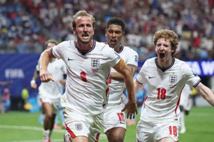 England forward Harry Kane, wearing the #9 white kit and captain’s armband, celebrates after scoring with teammates Jude Bellingham #10 and Anthony Gordon #18 during the FIFA World Cup 2026 Round of 32 match against Congo DR at Atlanta Stadium in Atlanta, Georgia, on July 1, 2026.