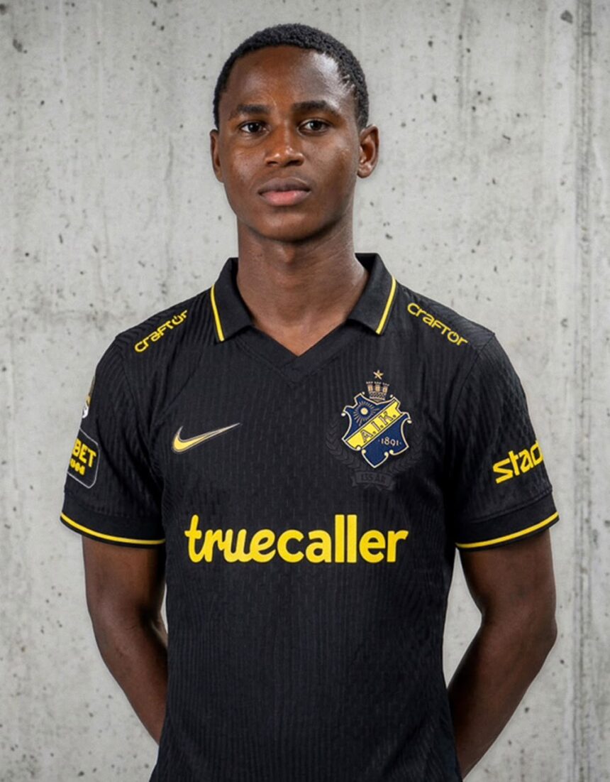 Portrait of a young man in a black AIK football jersey with yellow trim standing against a concrete wall The kit features the AIK crest and the sponsor truecaller in yellow  trybalnews