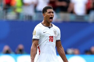 Jude Bellingham, wearing the white England #10 jersey, celebrates with his mouth open and fists clenched after scoring for England in the FIFA World Cup 2026 Quarter Final vs Norway at Miami Stadium. Photo by Dan Mullan/Getty Images