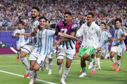 Julian Alvarez #9 of Argentina celebrates with arms outstretched as teammates mob him after scoring Argentina's second goal in the FIFA World Cup 2026 Quarter Final against Switzerland at Kansas City Stadium. Photo by Carl Recine/Getty Images