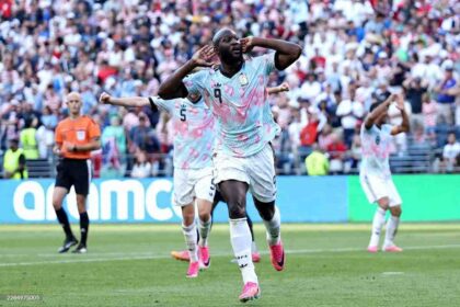 Belgium forward Romelu Lukaku #9 celebrates with hands to ears after scoring Belgium's fourth goal during the 2026 FIFA World Cup Round of 16 match between USA and Belgium at Seattle Stadium in Seattle on July 6, 2026. Belgium teammates #5 and #8 celebrate behind him.