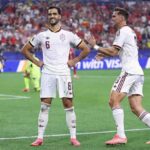 Spain midfielder Mikel Merino 6 smiles with hands on hips as he celebrates his teams first goal during the 2026 World Cup round of 16 match between Portugal and Spain at Dallas Stadium in Arlington on July 6 2026 A Spain teammate in jersey 8 approaches to congratulate him  trybalnews