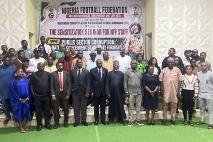 Group of men and women in formal and traditional attire pose on steps in front of a Nigeria Football Federation banner at an anti-corruption seminar event.