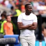 Senegal head coach Pape Thiaw stands on the touchline with his arms crossed looking intently toward the pitch during the FIFA World Cup 2026 Round of 32 match between Belgium and Senegal at Seattle Stadium in Seattle Washington on July 1 2026  trybalnews