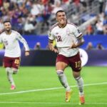Spain defender Pedro Porro wearing jersey number 12 in white and maroon celebrates with arms outstretched and mouth open after scoring Spains second goal in the FIFA World Cup 2026 Semi Final vs France at Dallas Stadium in Arlington Texas A teammate in jersey number 19 runs behind him on the pitch with a packed stadium in the background  trybalnews