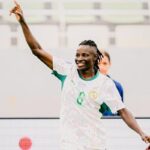 Soccer player in white and green jersey with number 6 celebrating right arm raised in the air on the field  trybalnews