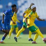 Soccer players in blue and yellow chase the ball on a green field during a match  trybalnews