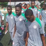 A group of young male soccer players in gray and green jerseys standing in a line on a turf field  trybalnews
