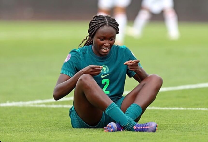 Female soccer player in a green jersey with number 2 sits on the grass pointing to her chest  trybalnews